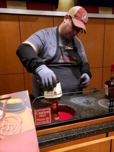 Chef Micah dipping a bottle of Maker's Mark at the distillery in Loretto, KY.